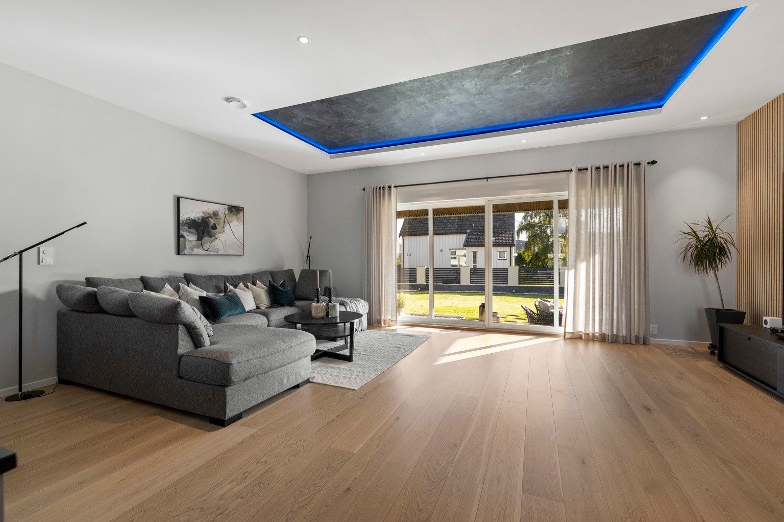 I den ene delen av rommet er det plass til en stor sofagruppe med tilhørende tv-møblement. Fra rommet er det utgang til en skiferbelagt uteplass. Galleribilde