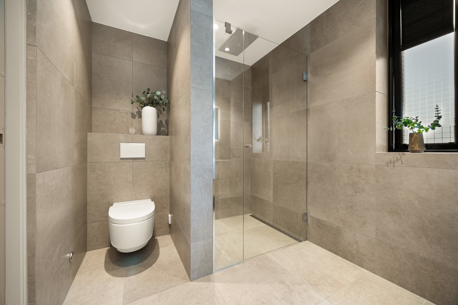 Badet har romslige dusjnisjer med regnfallsdusj, hånddusj og glassdører. Galleribilde