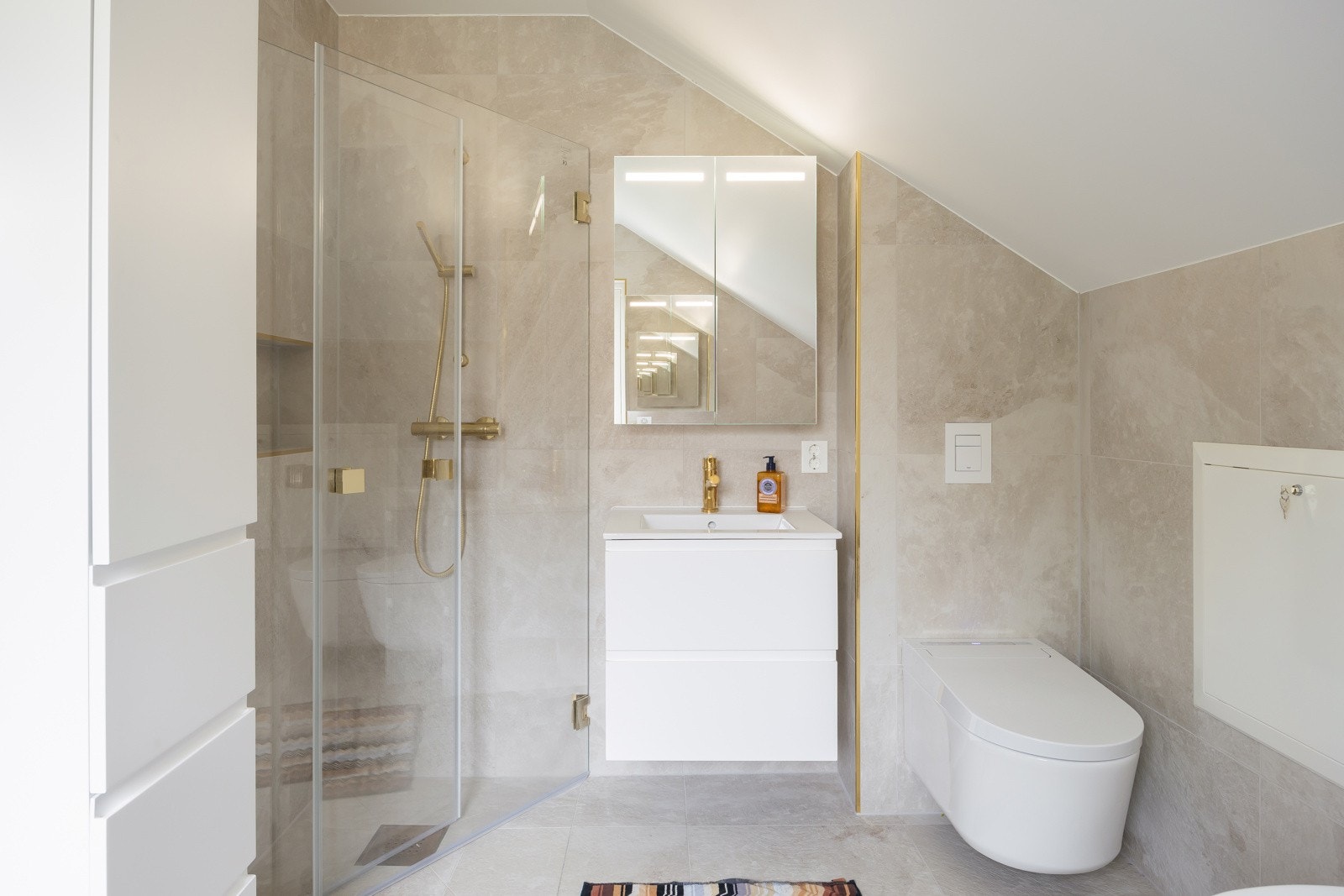 Bad ved hovedsoverom har behagelig varme i gulvet, eksklusive gulldetaljer og moderne spyletoalett. Galleribilde