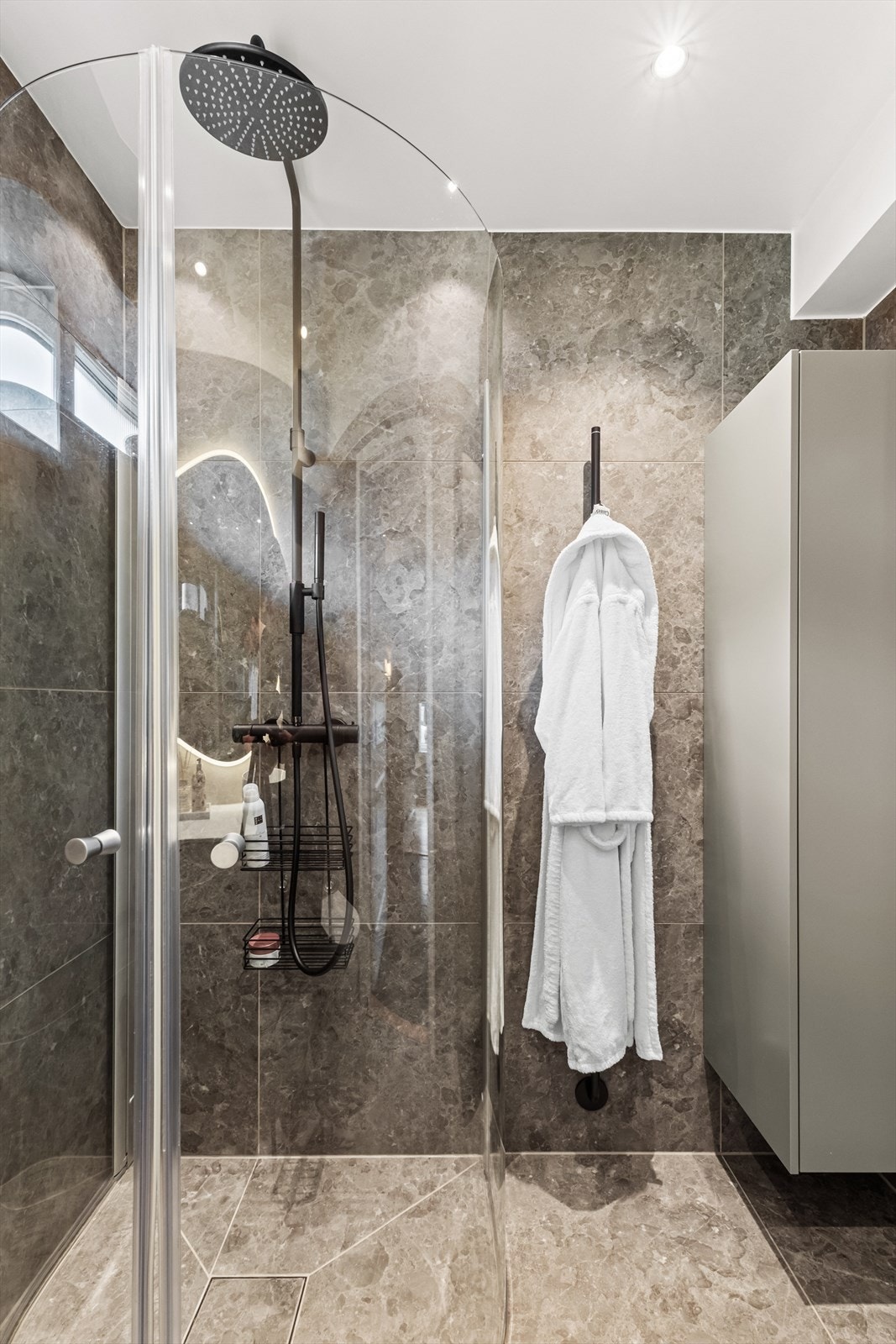 Alt av armatur fra Tapwell. Dusjhjørne med regndusj, hånddusj og glassdører. Elektrisk håndkletørker og høyskap montert på vegg. Elektrisk avtrekksvifte i yttervegg. Galleribilde