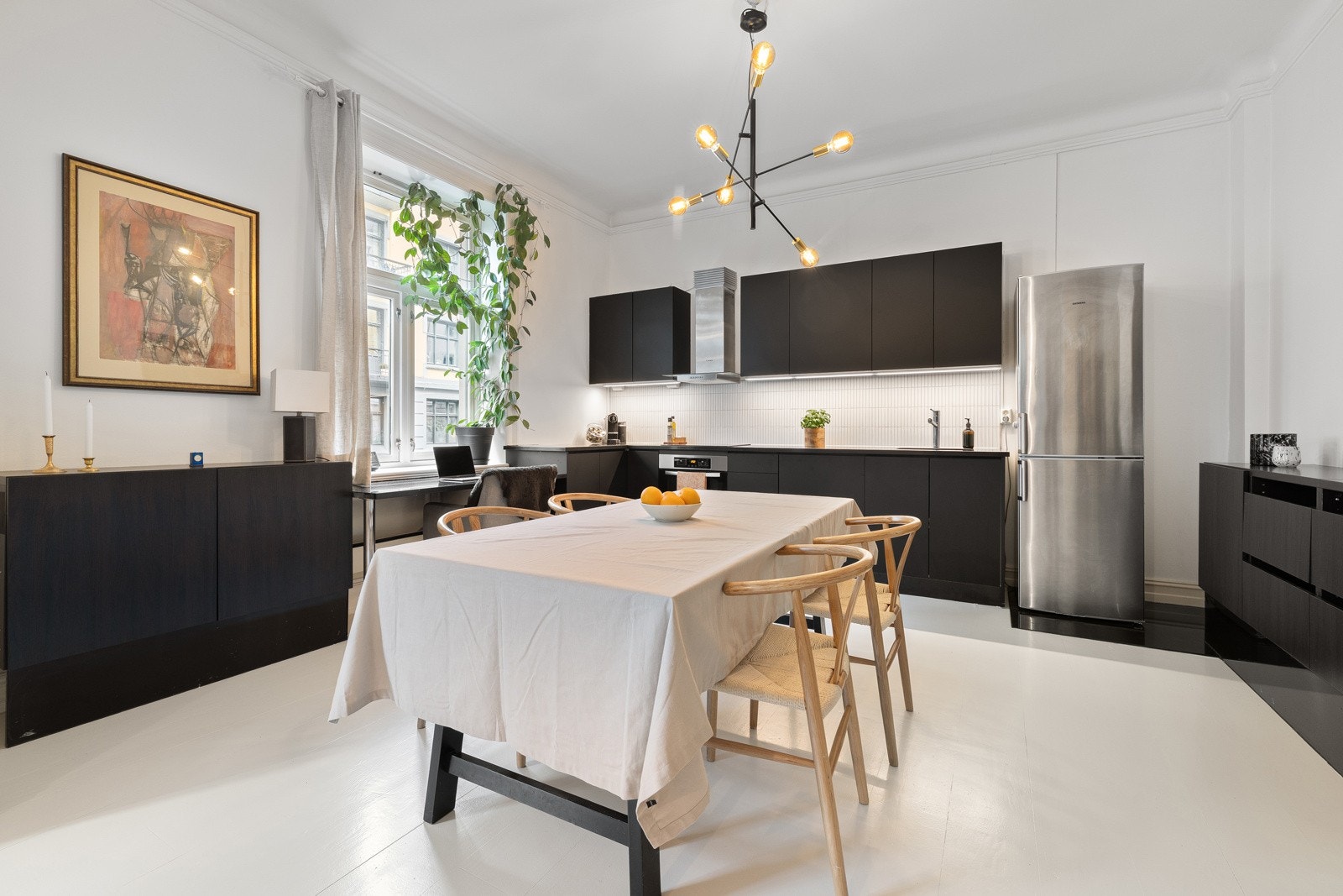 Kjøkkenet har en moderne innredning med glatte fronter og benkeplate i stein. Galleribilde