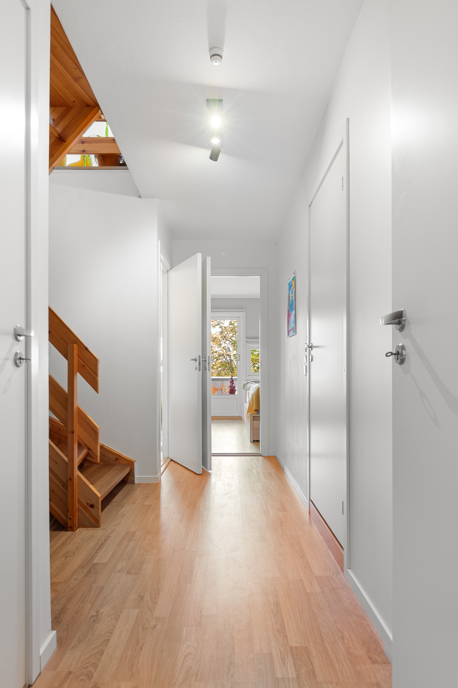 Underetasjen har en åpen og oversiktlig gang med praktisk bod og lagringsmuligheter under trappen. Galleribilde