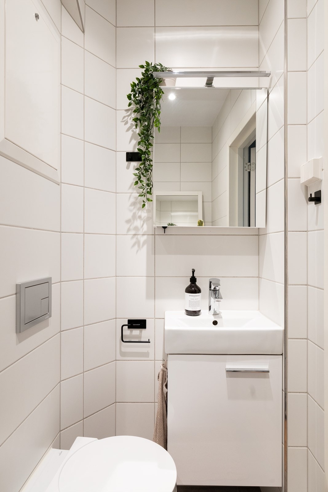 Badet er innredet med vegghengt klosett, servant med innredning, speilskap m/lys og dusjhjørne med svingbare glassdører. Galleribilde