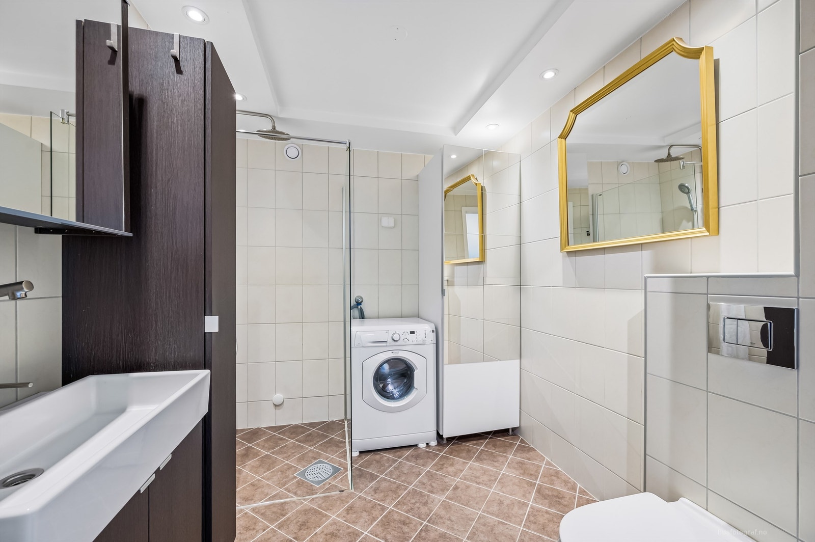 Badet har dusj i hjørne med dusjvegg av glass, regnfallsdusj samt opplegg for dusjforheng Galleribilde