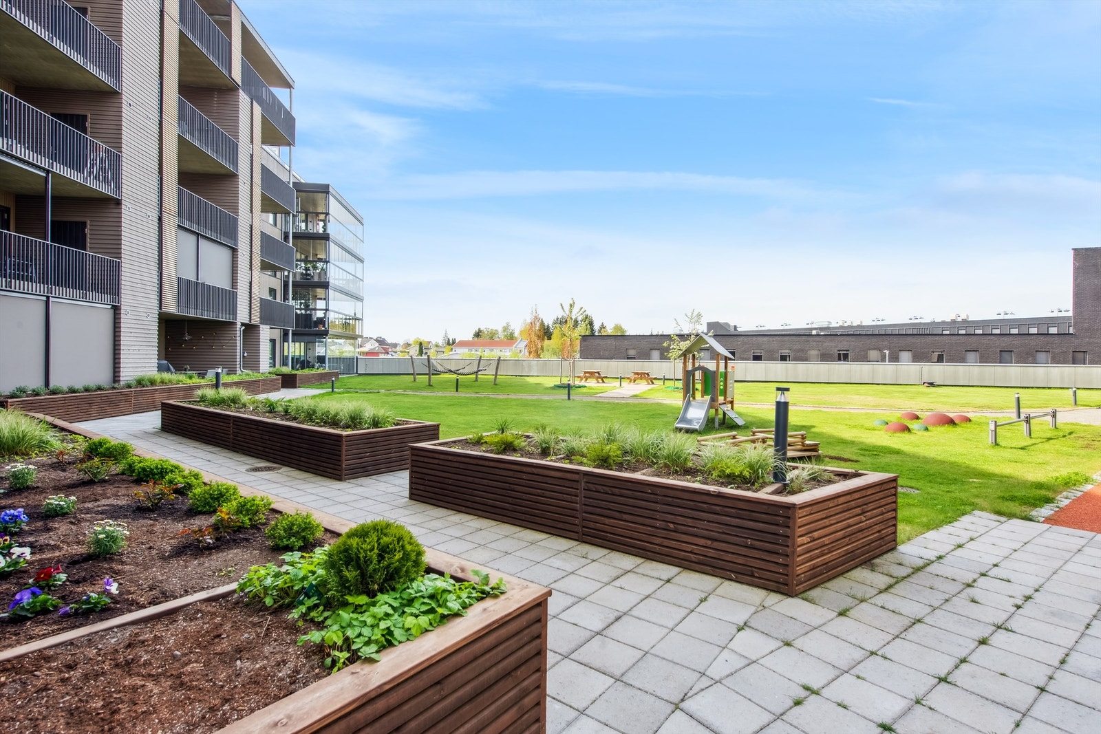 Atriet inne i sameiet er meget pent opparbeidet med plen, blomsterkasser, betongheller og lekeapparater. Galleribilde