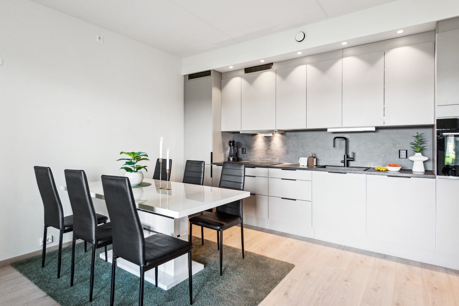 Kjøkkenet har integrerte hvitevarer som kjøl- og fryseskap, koketopp, oppvaskmaskin og stekeovn Galleribilde