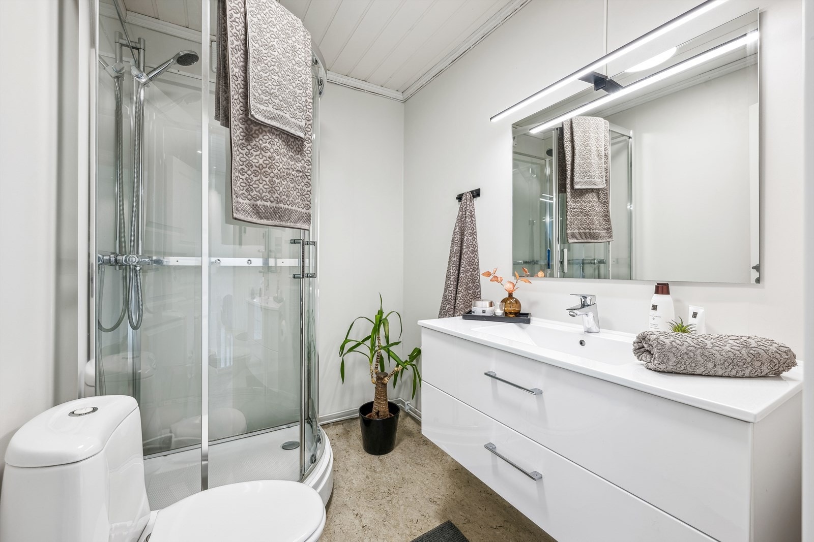 Badet har servantskap med helstøpt servant, toalett og dusjkabinett (bilde er fra forrige salg i 2024) Galleribilde