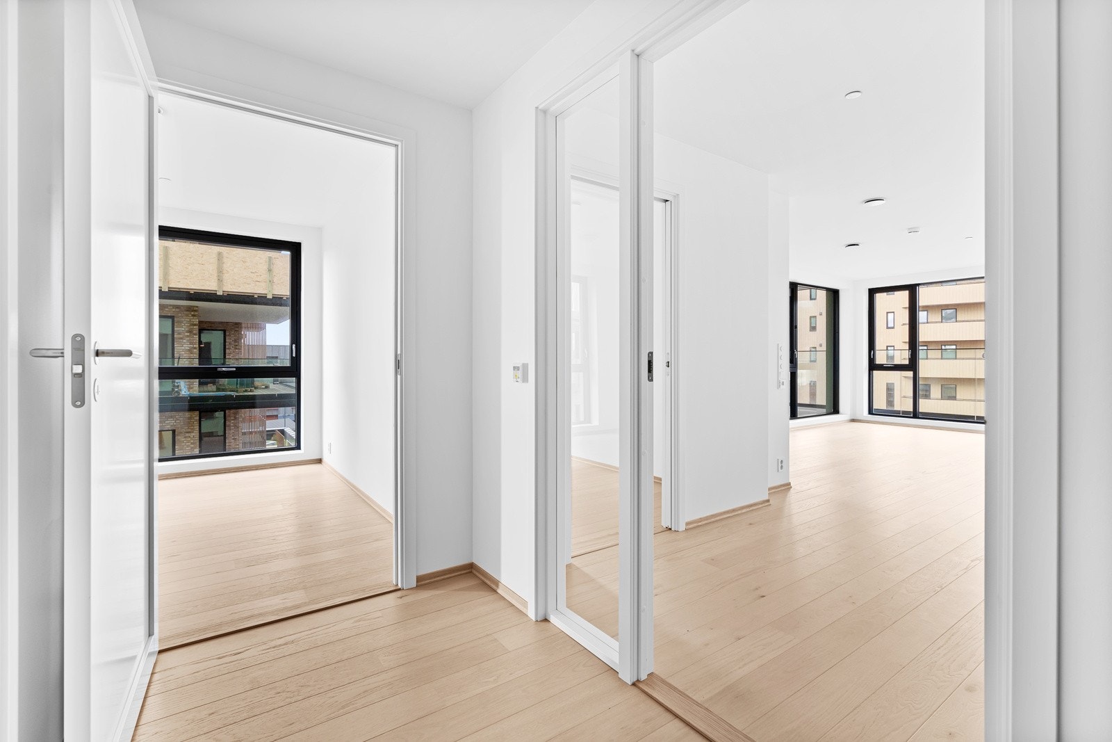 Dør mellom gang og stue/kjøkken har vindu i seg, slipper lyset innover i leiligheten. Galleribilde