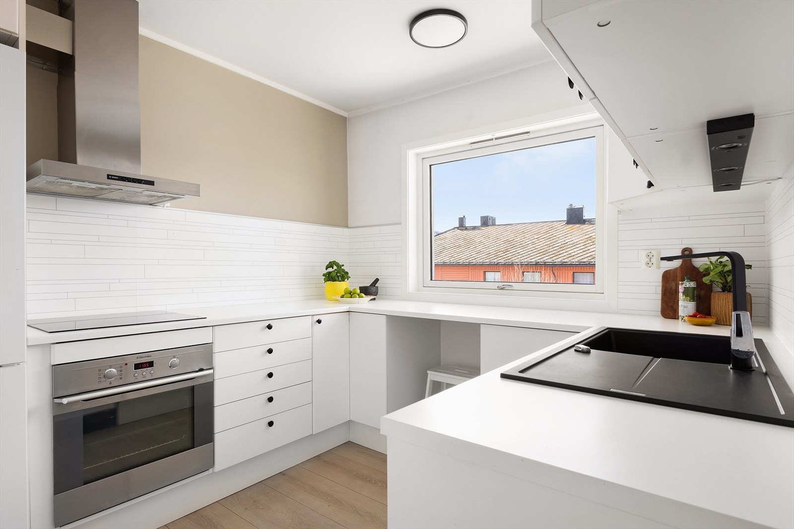 Kjøkkenet er smart innredet med slette fronter og en praktisk laminert benkeplate, noe som gir et stilrent og moderne uttrykk. Galleribilde