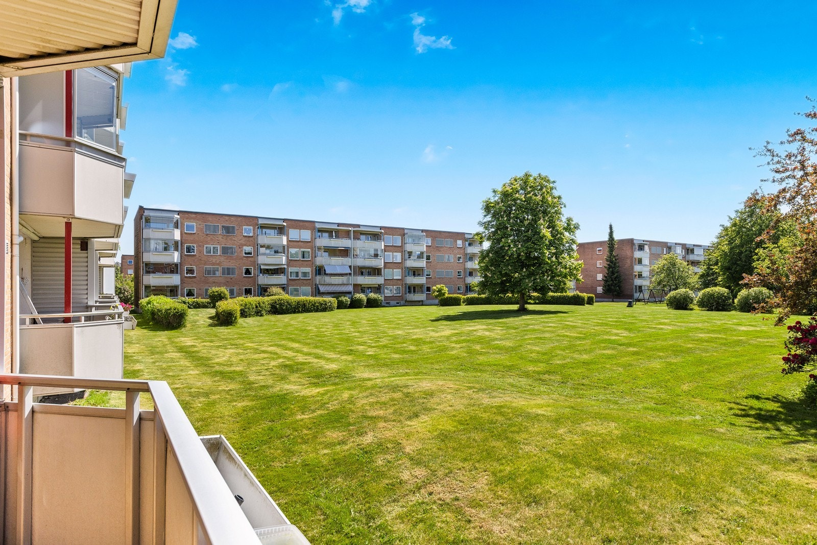 Fin utsikt mot store og grønne fellesområder fra balkongen Galleribilde