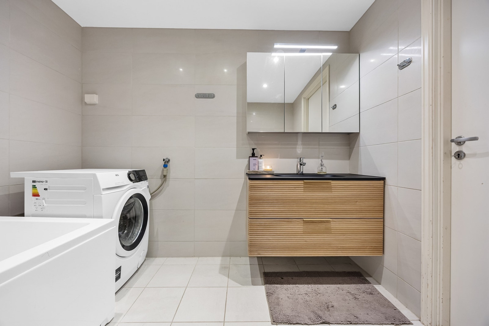 Det er stor innredning med god plass til oppbevaring i servantskuffer, i tillegg til speilskap med belysning. Galleribilde