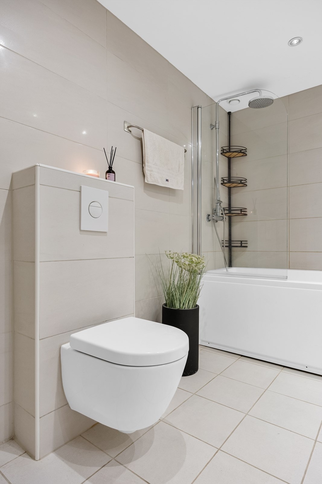 Det er vegghengt toalett, badekar med regnfallsdusj og glassvegg. Galleribilde