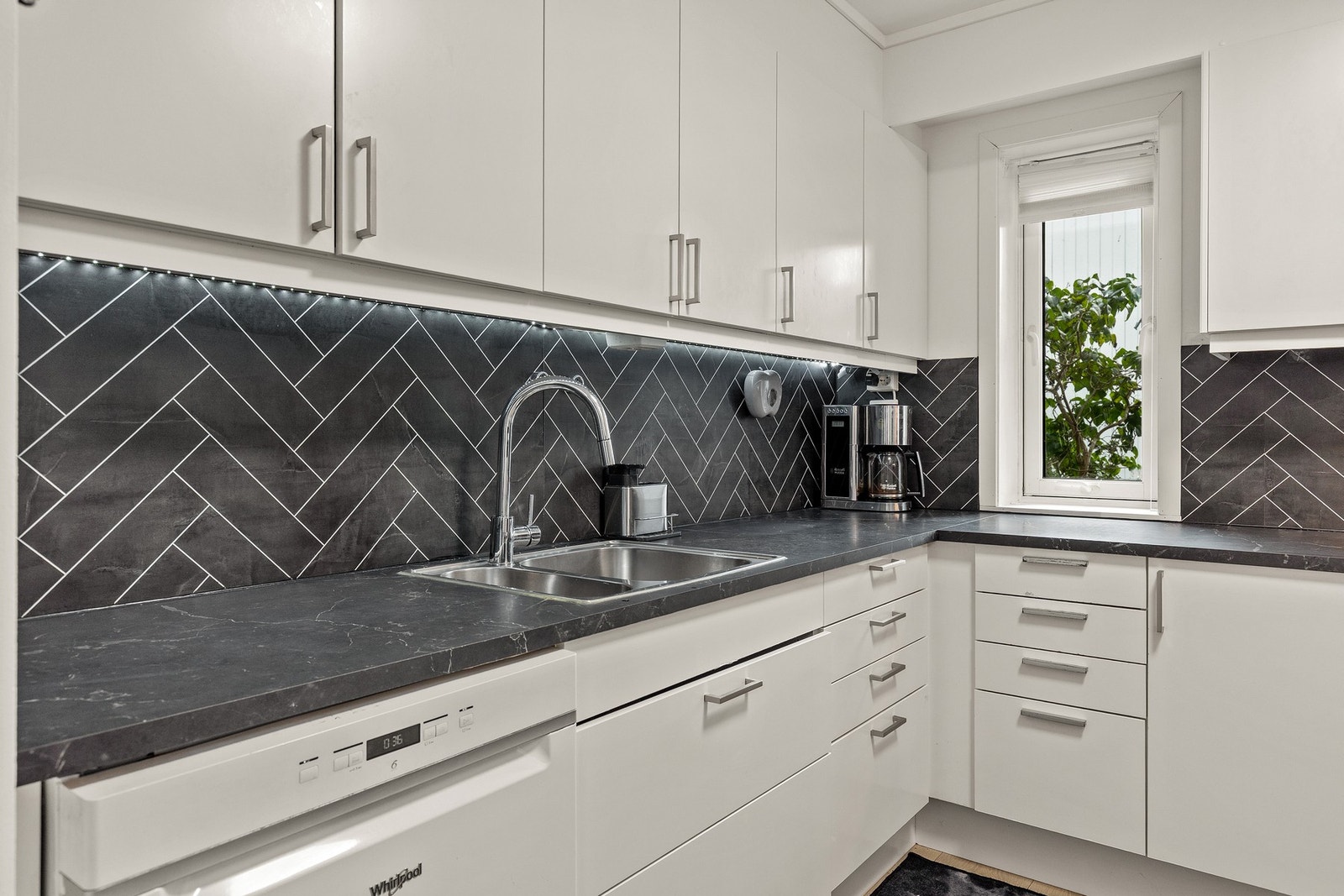 Det er integrert stekovn og platetopp - Innredning med opplegg for oppvaskmaskin, benkebereder og mekanisk avtrekksvifte over stekesonen. Galleribilde