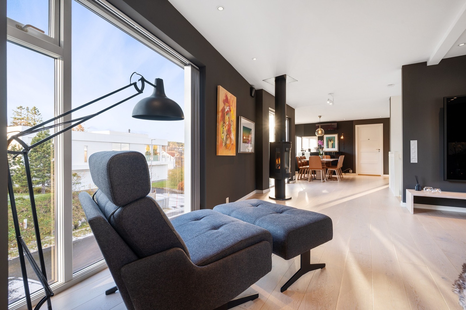 Vinduer fra gulv til tak på flere vegger i stua gir masse naturlig lys inn Galleribilde