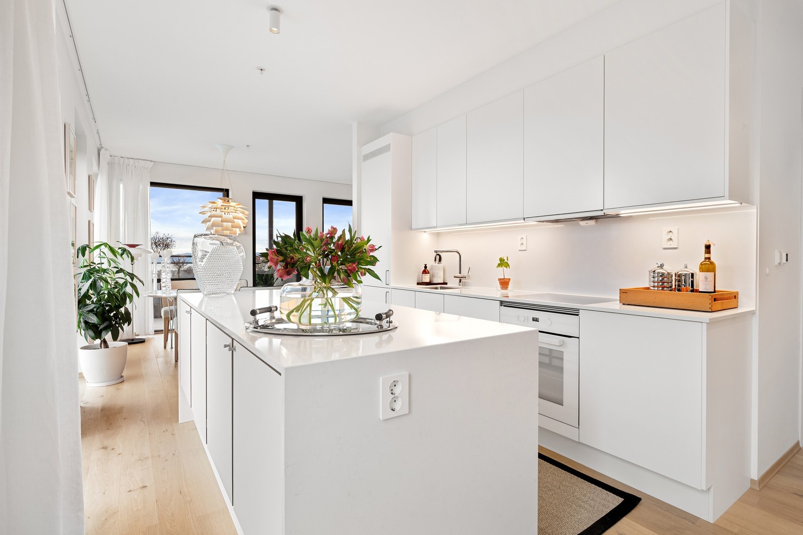 Hvit, stilren innredning med integrerte Miele hvitevarer. Galleribilde