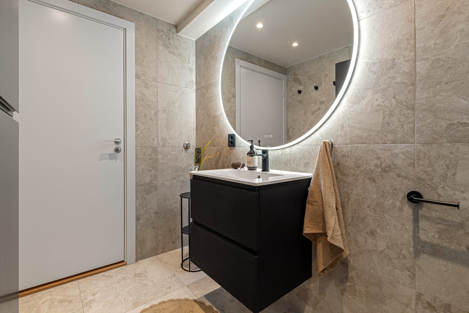 Speil med LED-belysning. Det er opplegg for vaskemaskin på baderom. Galleribilde