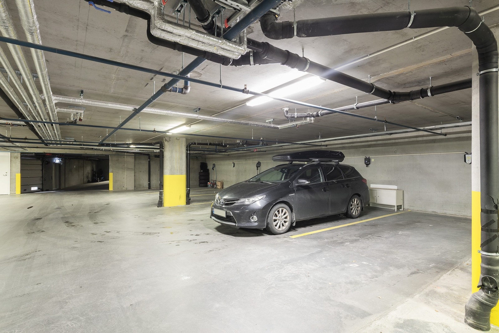 Det medfølger egen parkeringsplass i kjeller med mulighet for elbillader. Det finnes også gjesteparkeringer på utsiden av blokka Galleribilde