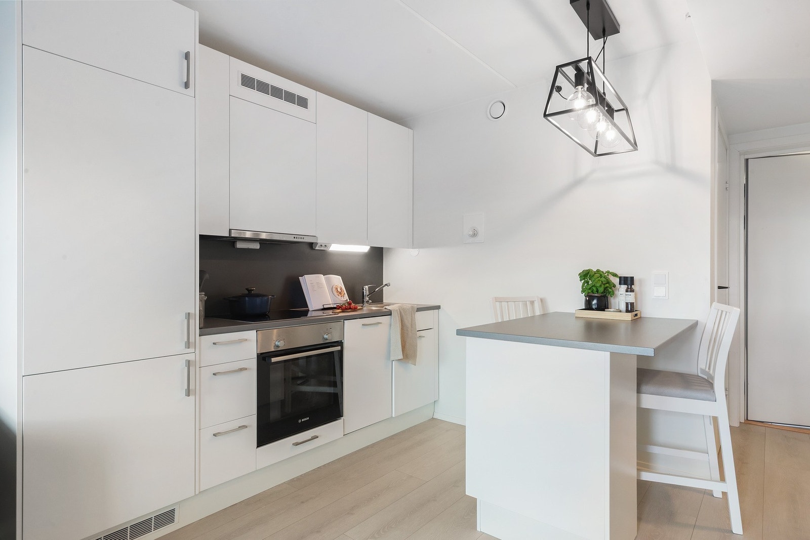 Lyst, tidløst kjøkken med integrert kjøle-/og fryseskap, stekeovn, platetopp og oppvaskmaskin Galleribilde