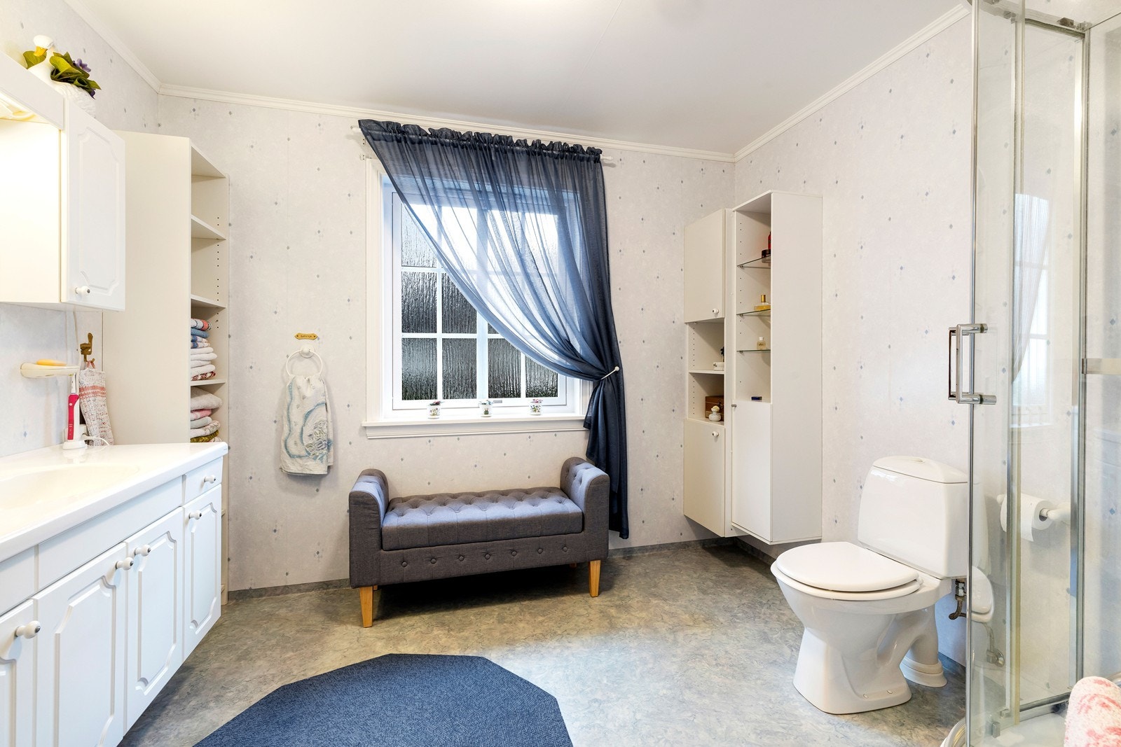 Badet er innredet med dusj, toalett og servant med innredning Galleribilde