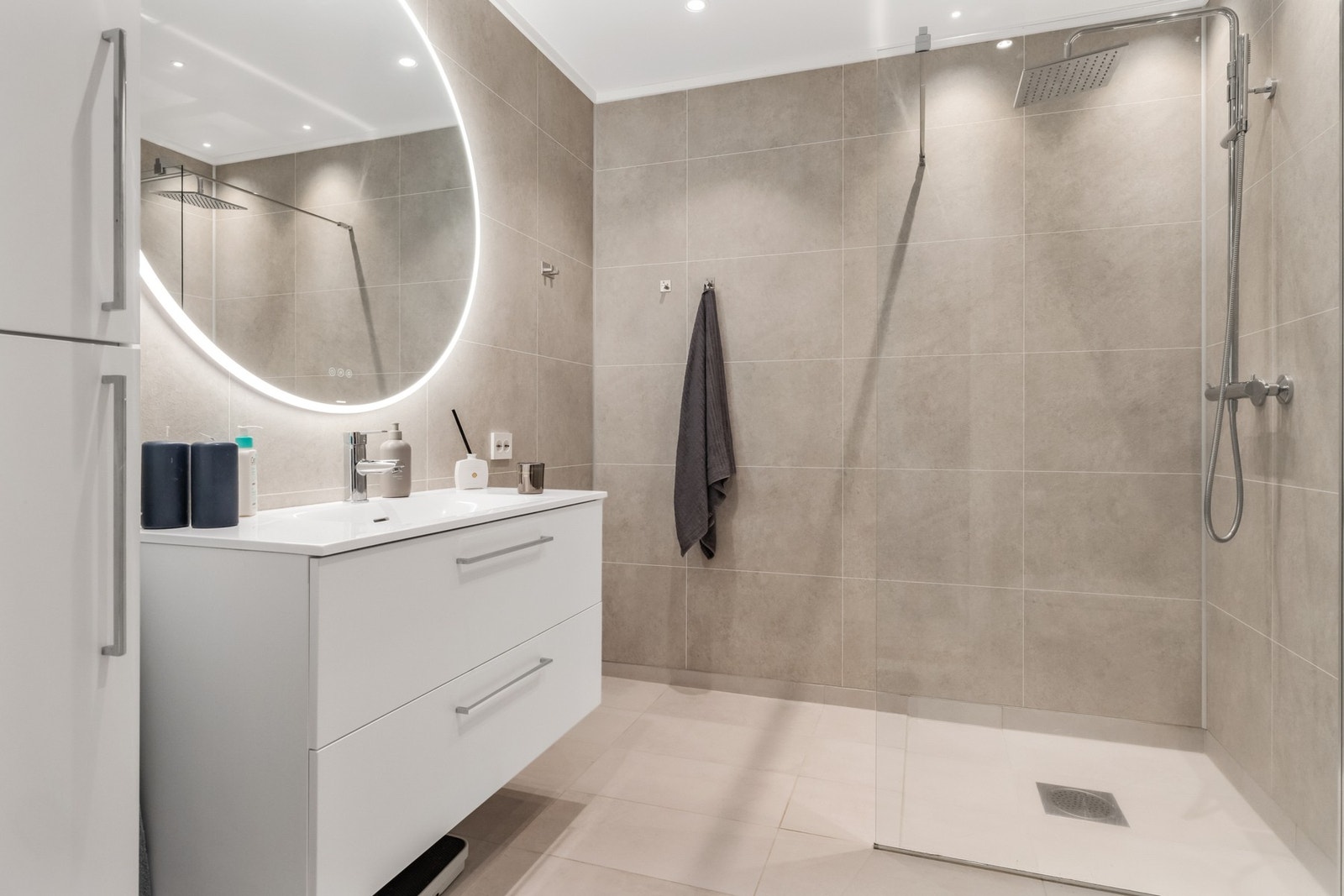 Lekkert og funksjonelt bad med moderne overflater Galleribilde