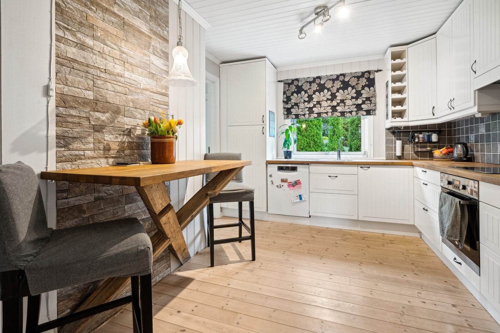 Innholdsrikt kjøkken med vinklet innredning og takhøye overskap fra 2010. Galleribilde