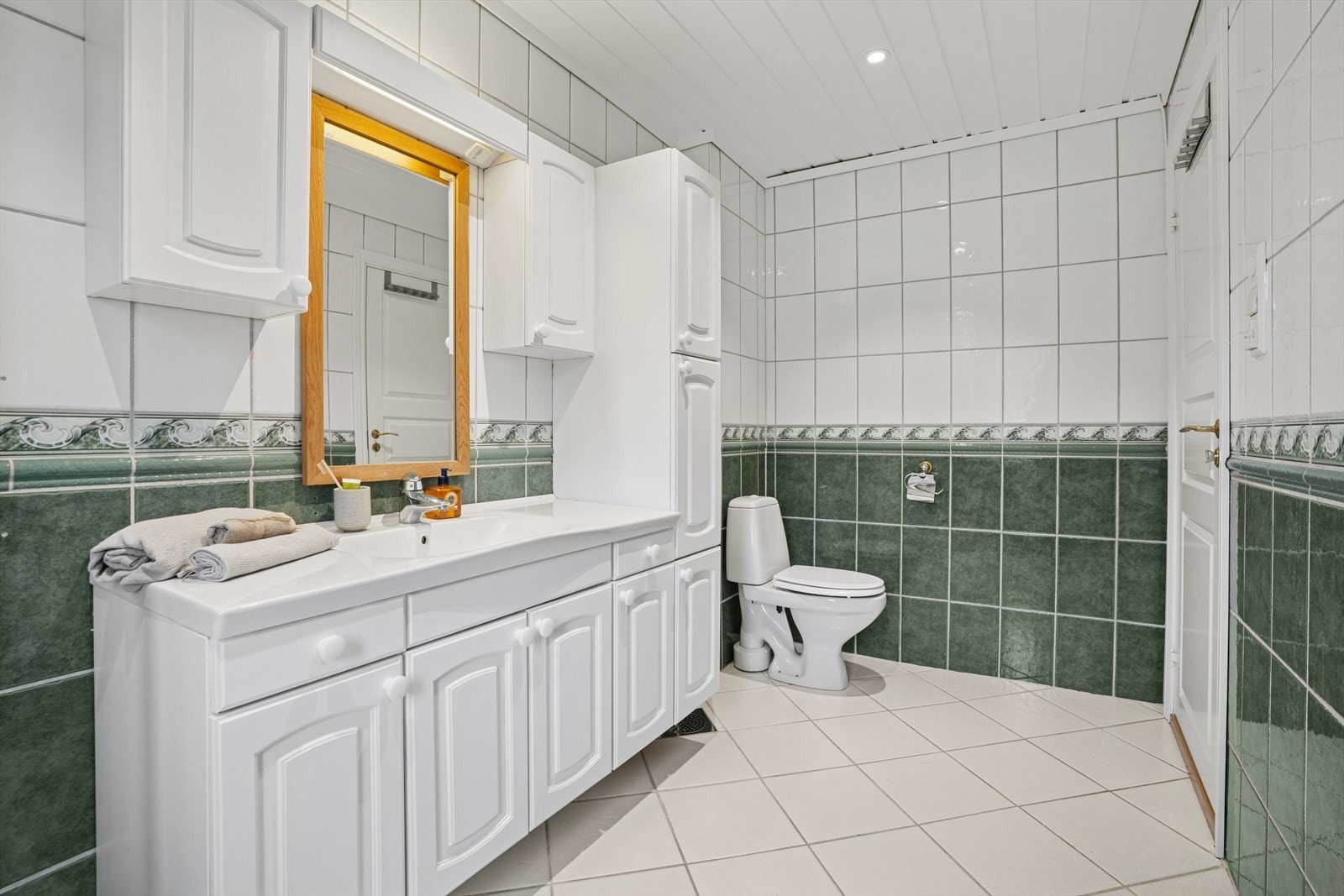 Badet er innredet med servantinnredning mes speil, toalett og dusjkabinett. Galleribilde