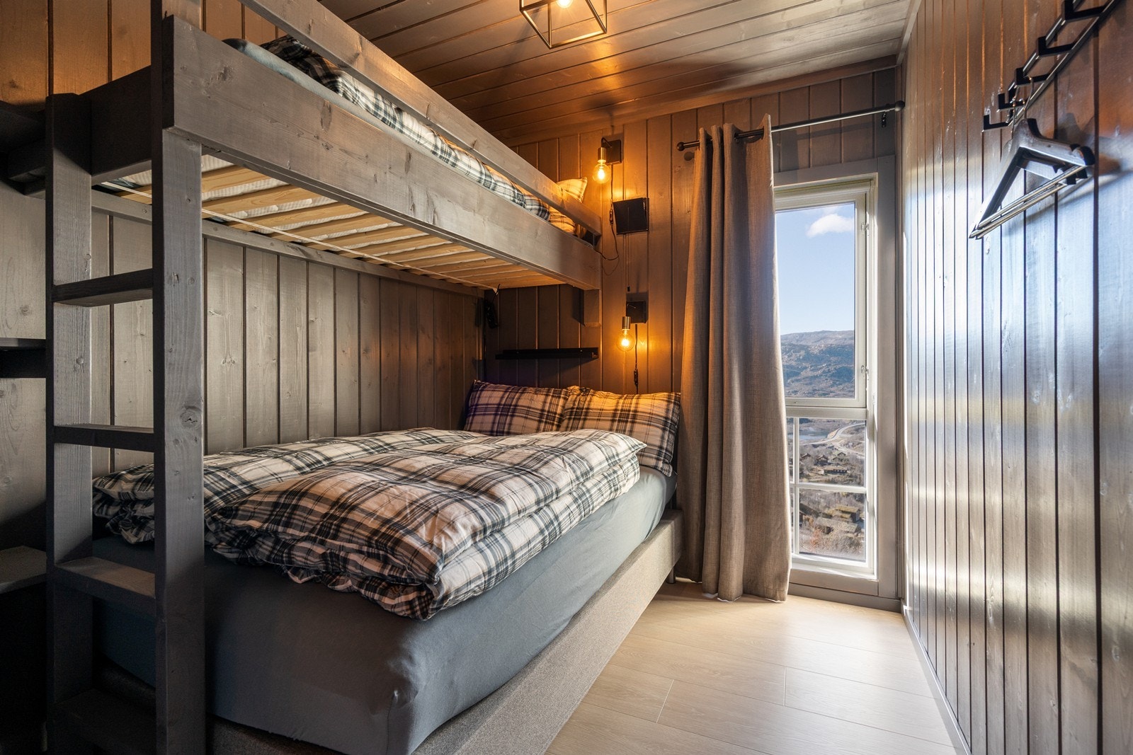 To av soverommene har plassbygde etasjesenger, smakfullt beiset i samme farge som vegg. Galleribilde