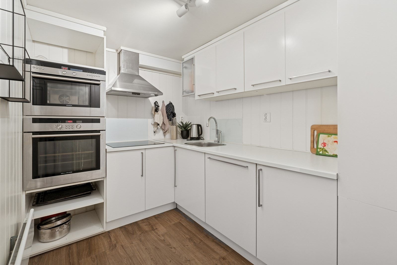 Kjøkkenet er moderne og funksjonelt, med glatte fronter og laminat benkeplate. Kjøkkenet er utstyrt med kjøkkenventilator med avtrekk ut, og hvitevarer som stekeovn, dampovn, induksjonstopp, oppvaskmaskin og kjøl/fryseskap følger med. Galleribilde