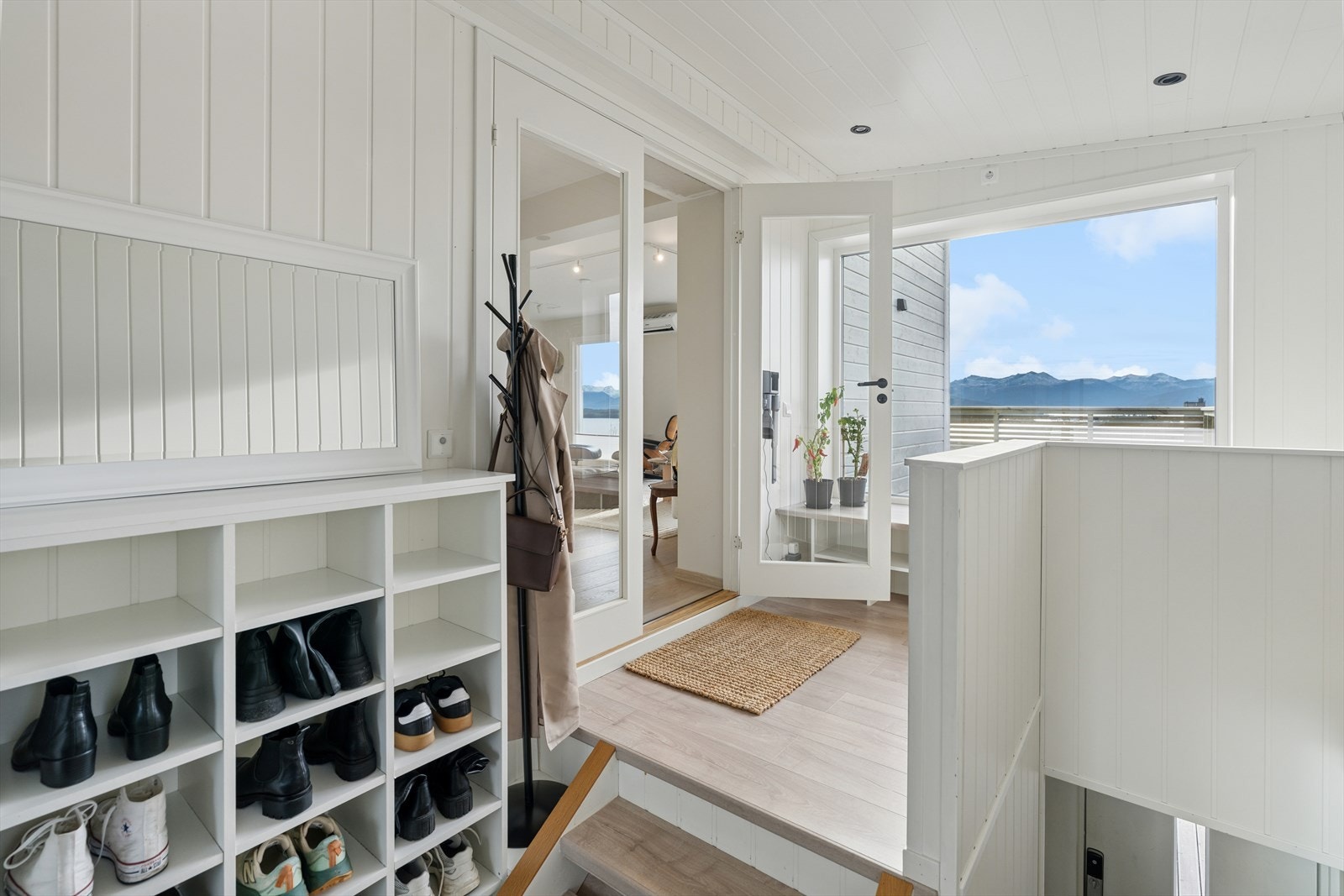 Fra en lys og innbydende entré med trapp opp, ledes du videre inn i boligens hovedetasje. Stort vindu slipper inn lys og utsikt. Downlights i taket og dobbel glassdør åpner opp til stue, kjøkken og spisestue i en åpen løsning. Galleribilde