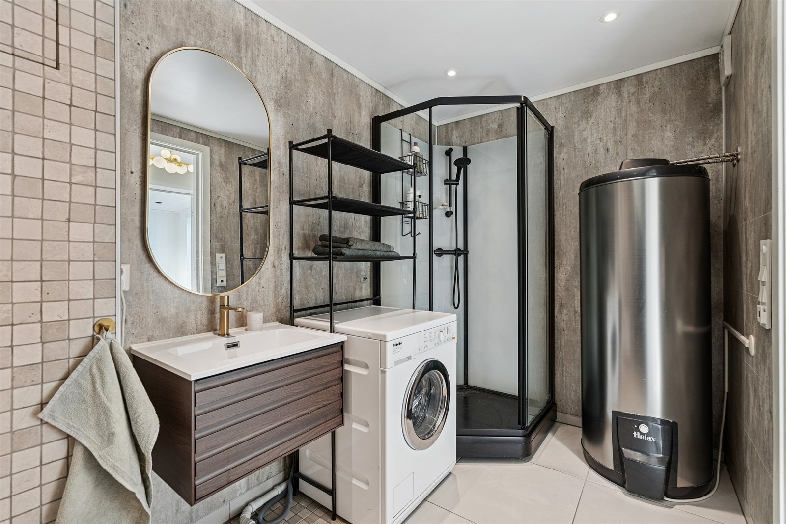 Badet fra 2018 har flislagt gulv med gulvvarme, våtromsplater og noe flis på veggene, samt malt himling med downlights. Rommet er innredet med heldekkende servant, vegghengt toalett med spylefunksjon og dusjhjørne. Galleribilde