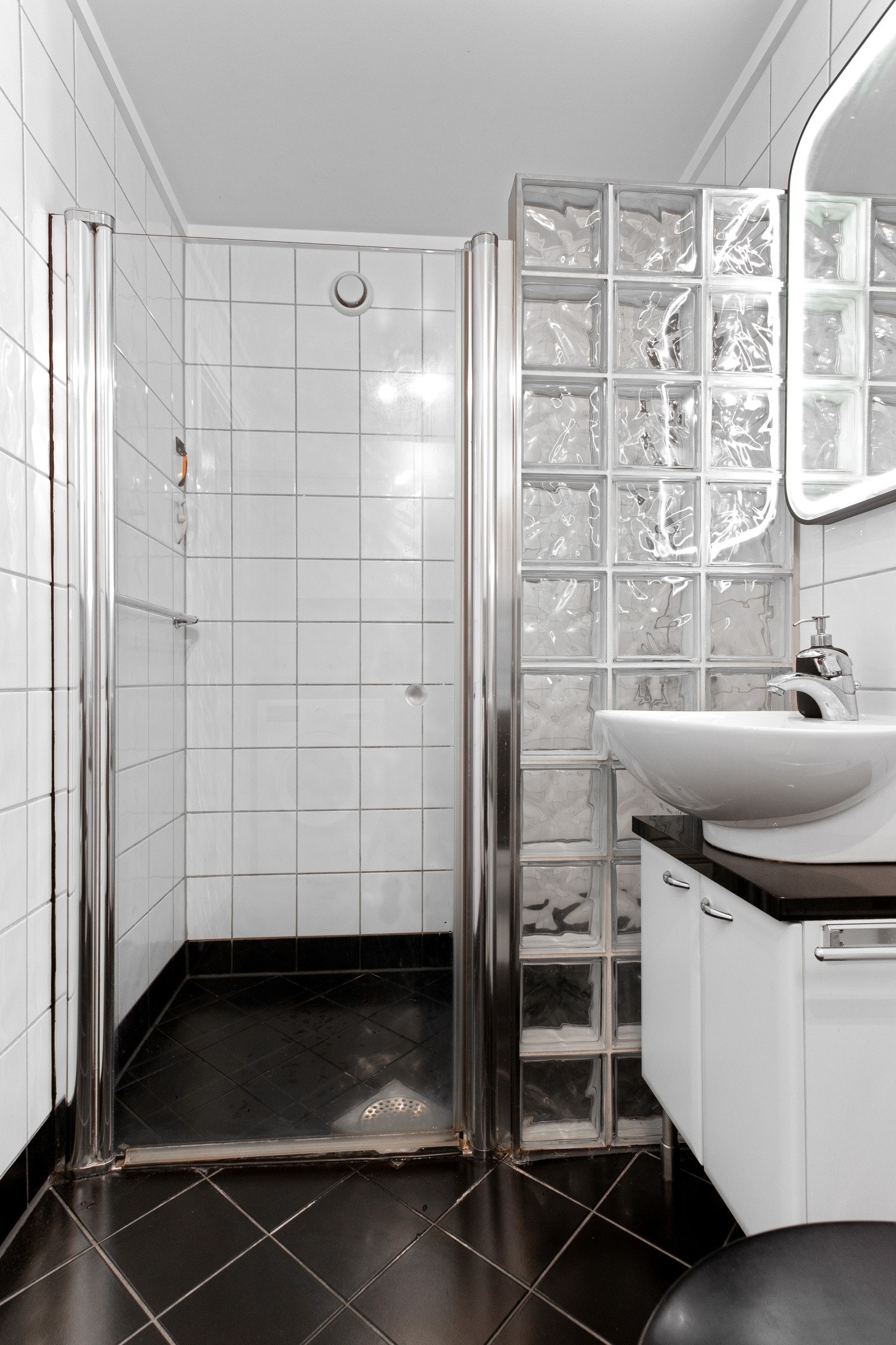 Badet har toalett, dusj og innredning med servant Galleribilde