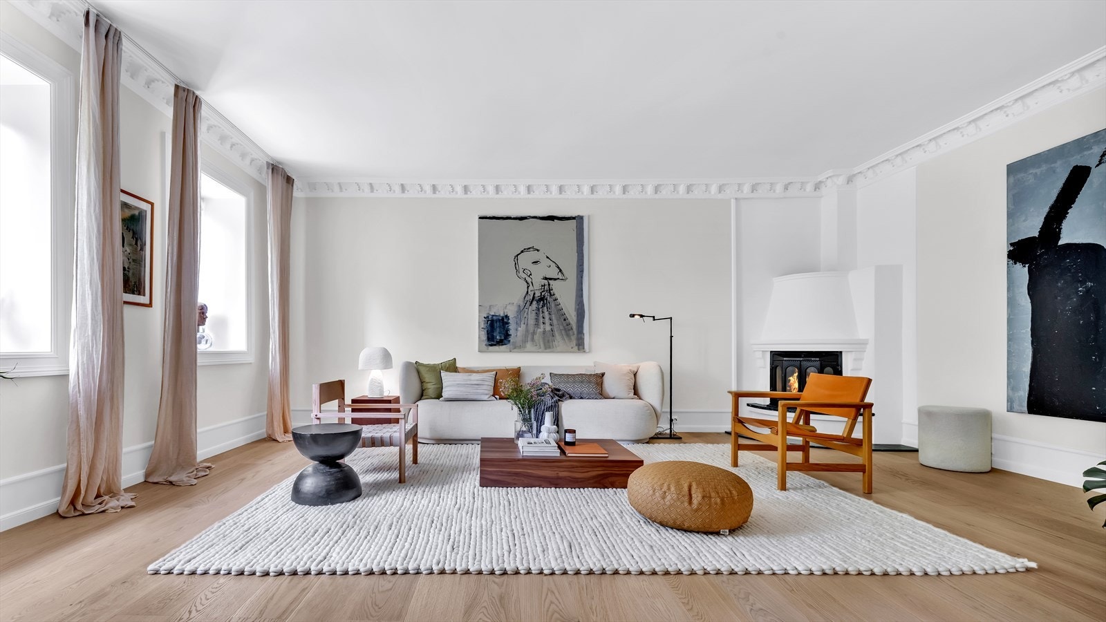 Dagligstuen er leilighetens hjerte, med store vindusflater og generøs takhøyde, hvilket gir en luftig romfølelse Galleribilde