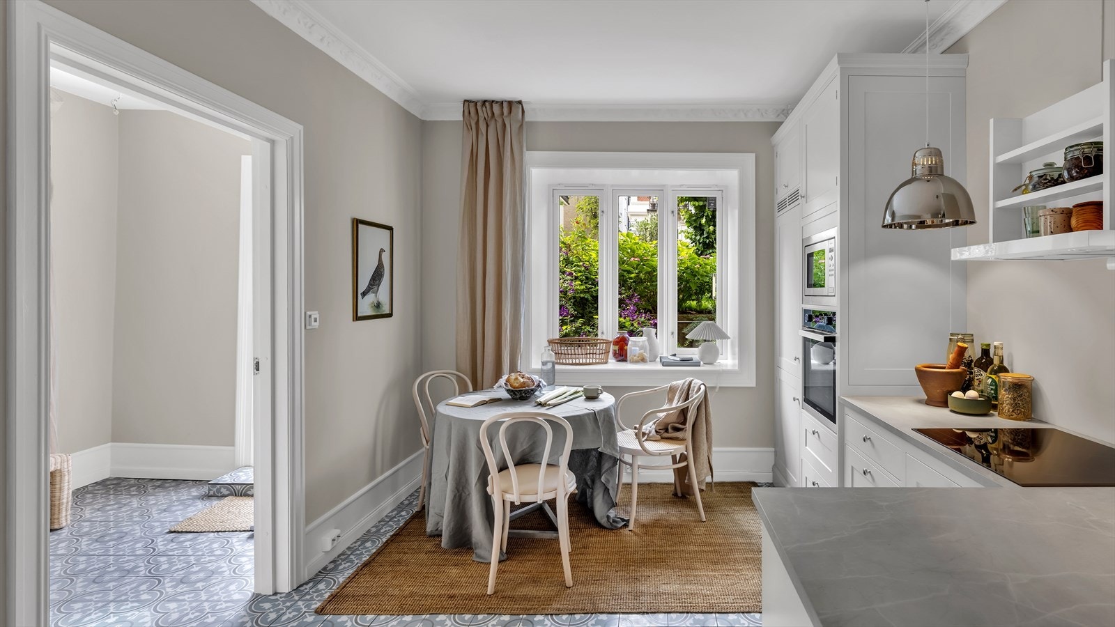 Kjøkkeninnredning fra Kvänum bestående av lyse profilerte fronter, benkeplate av laminat og nedfelt oppvaskkum med armatur fra Grohe med uttrekkbart munnstykke Galleribilde