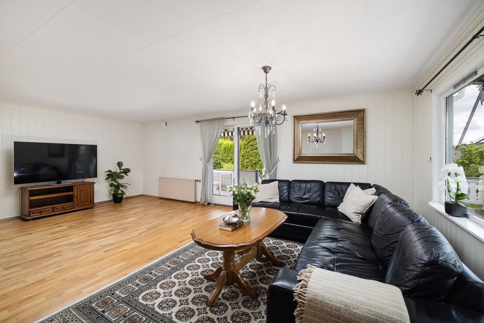 Tilbygget stue fra 1981 med utgang til uteplassene. Galleribilde