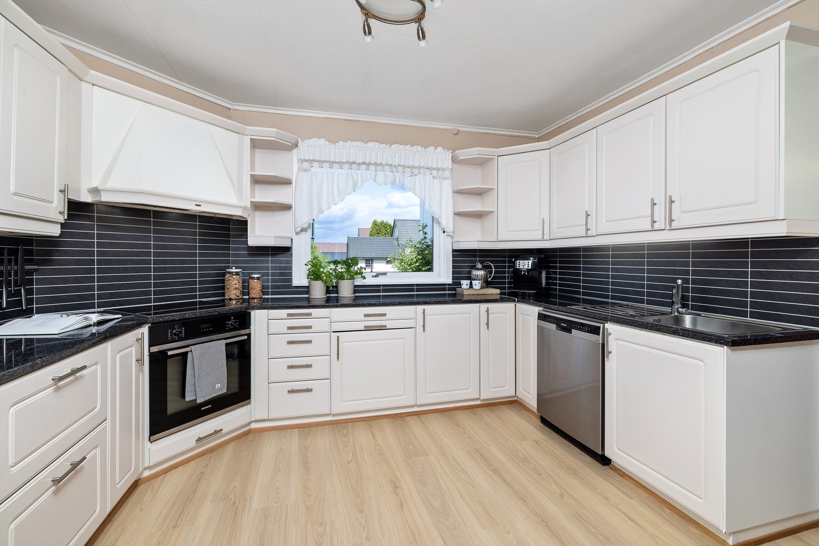 Praktisk kjøkken med integrerte hvitevarer, montert i u-form. Galleribilde