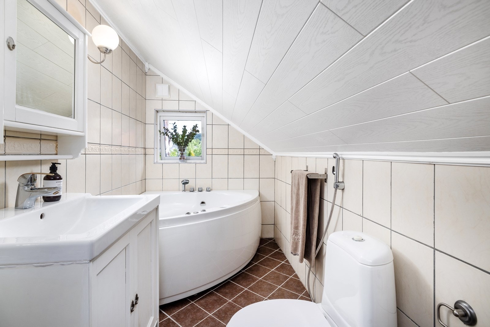 Bad i 2. etasje med hjønebadekar. Rommet er for lite til å kunne godkjennes som bad. Varmekabler i gulv. Galleribilde