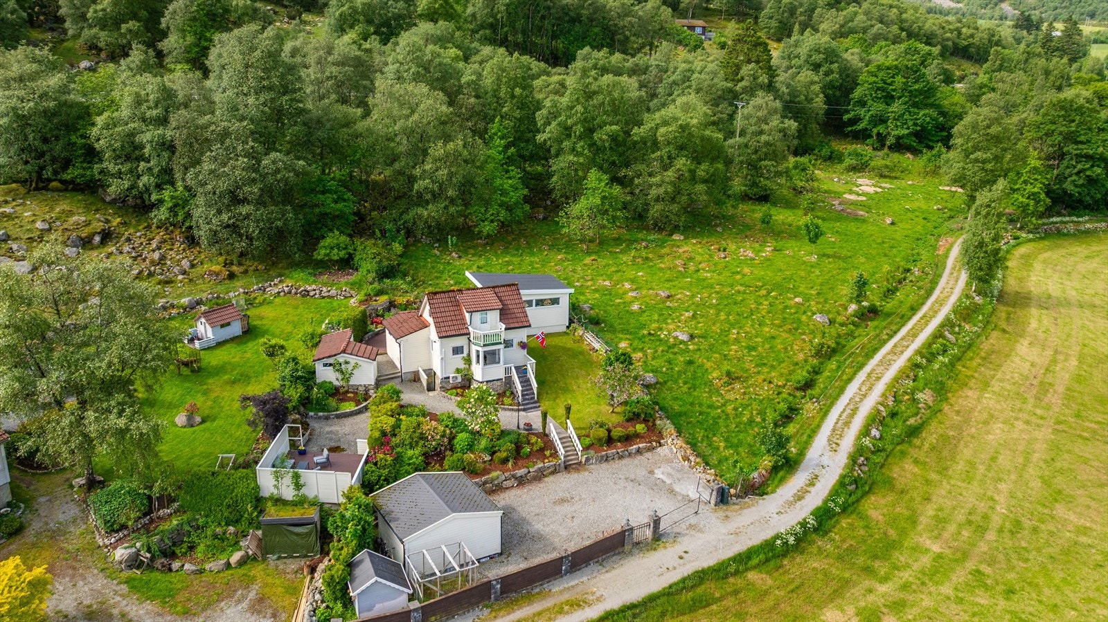Denne idylliske fritidseiendommen byr på en unik mulighet til å senke skuldrene og nyte naturen. Med vei helt frem og parkering på egen tomt, blir du møtt av en nydelig, velstelt hage på vei opp til hytta. Galleribilde