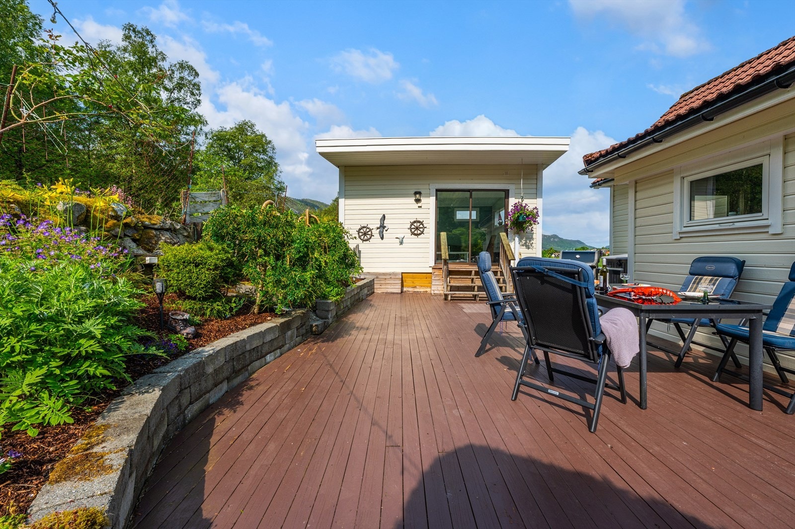 Tomten er smakfullt opparbeidet med terrasse/platting fordelt på forskjellige nivåer, noe som skaper spennende soner og en dynamisk utnyttelse av uteområdet. Dette gir varierte muligheter for avslapning og sosiale sammenkomster i naturskjønne omgivelser. Galleribilde