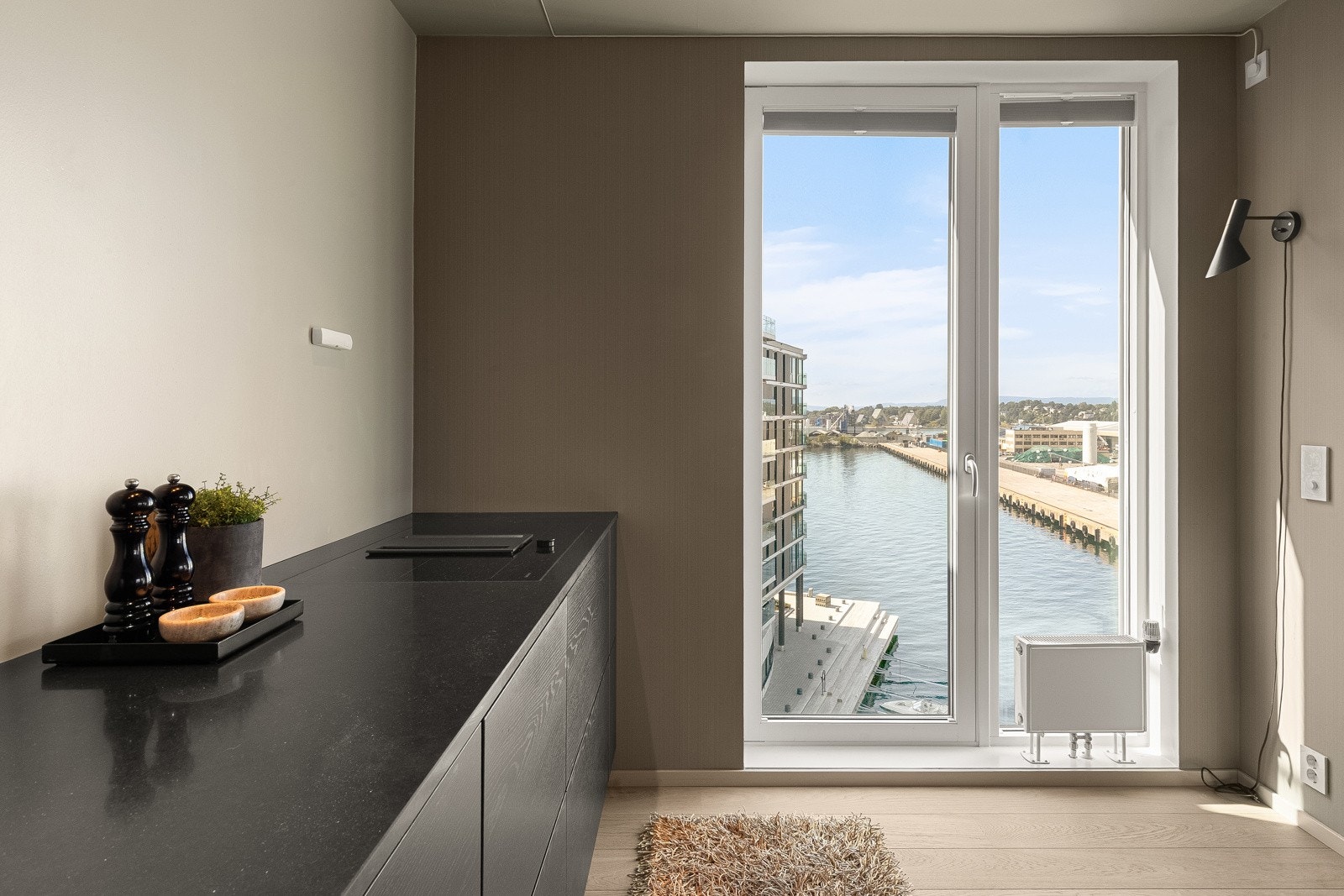 De slette skapdørene i eik er lakkert i en dempet nyanse av svart, noe som gir rommet både dybde og eksklusivitet Galleribilde