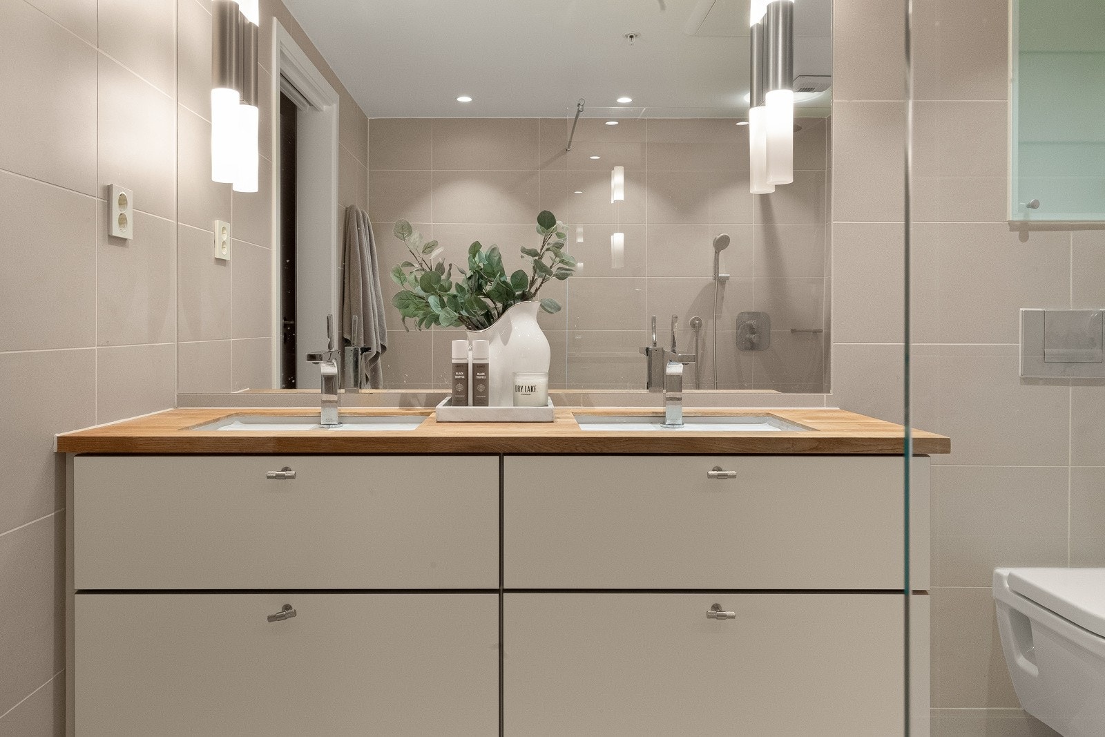 Innredningen består av heldekkende servant med to armaturer, stort speil og dusjhjørne med regnfallsdusj Galleribilde