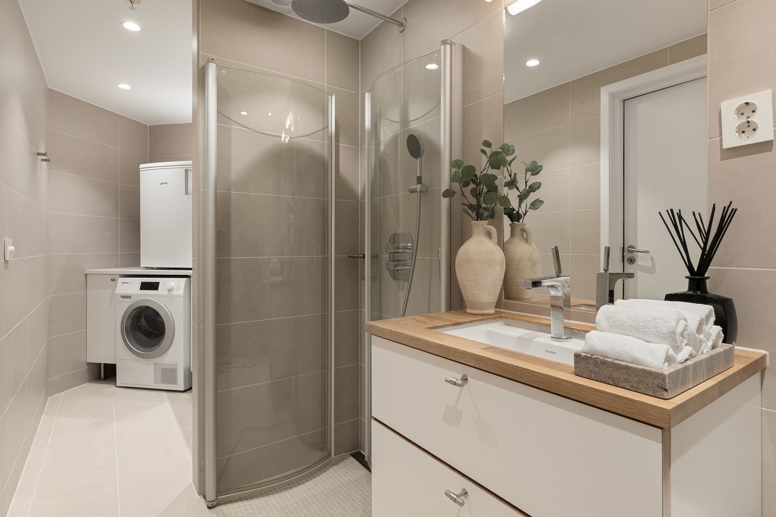 Baderom II er inndelt i to soner, med et pent og praktisk vaskerom i enden av rommet Galleribilde