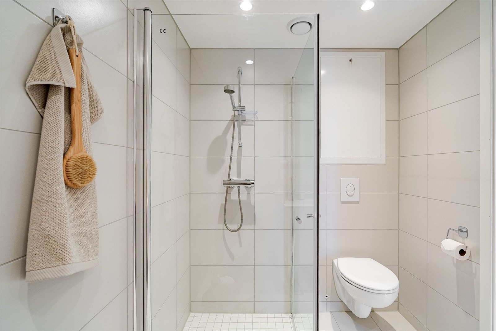 Badet har vegghengt toalett og spotter i taket Galleribilde