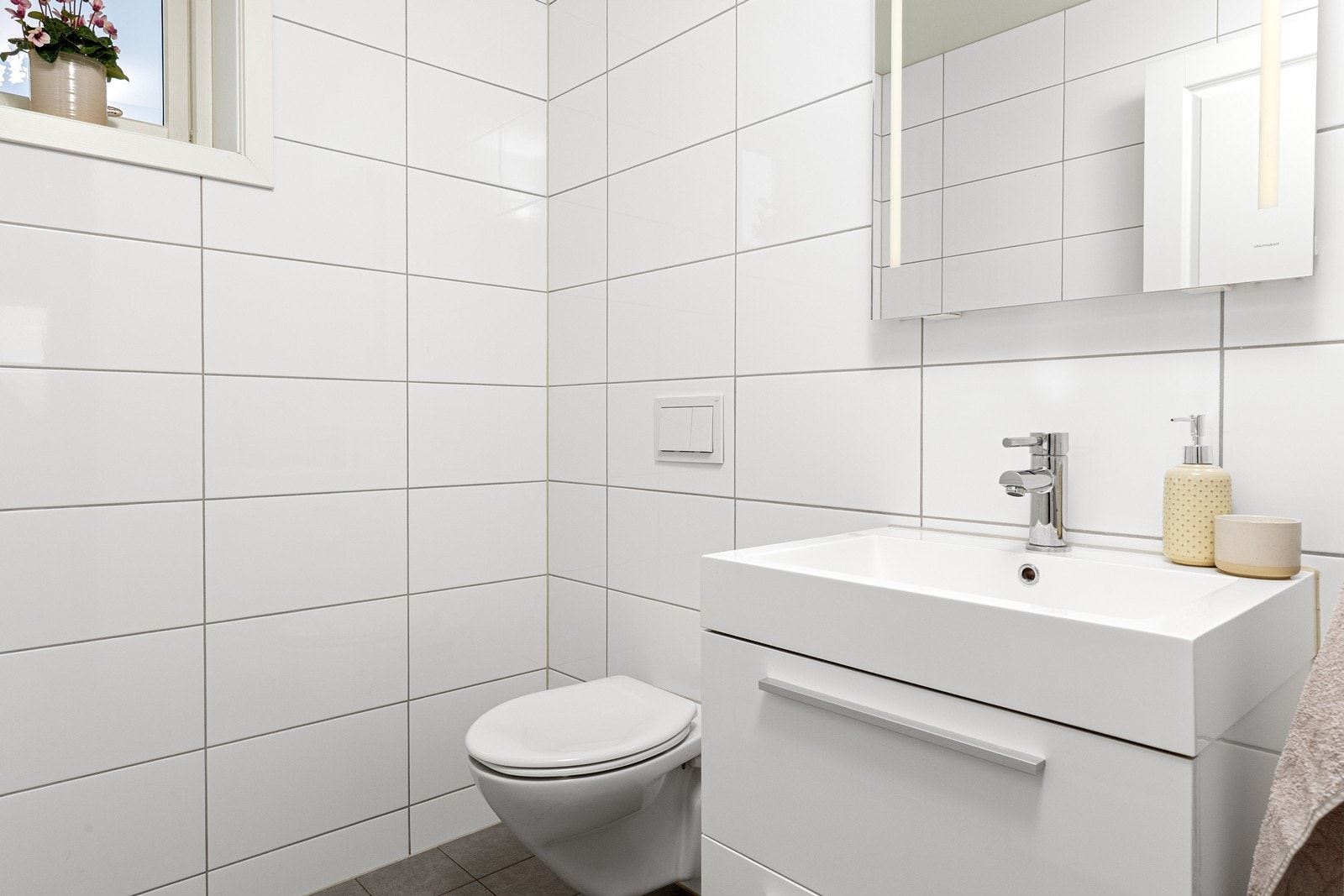 Toalettrommet har nedfelt servant, speil med lys og veggengt toalett. Galleribilde