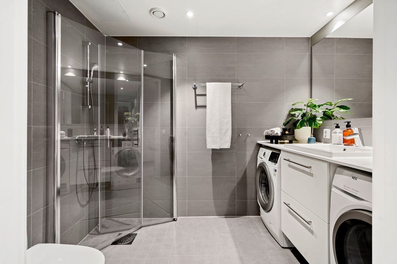 Pent flislagt bad som er moderne innredet med god oppbevaringsplass. Her er det gjort tilvalg på veggflisene som er oppgradert til 30x60 cm Porcelanto, Marte Elegance Grey- et eksklusivt tilvalg som gir rommet et elegant og tidløst uttrykk. Galleribilde