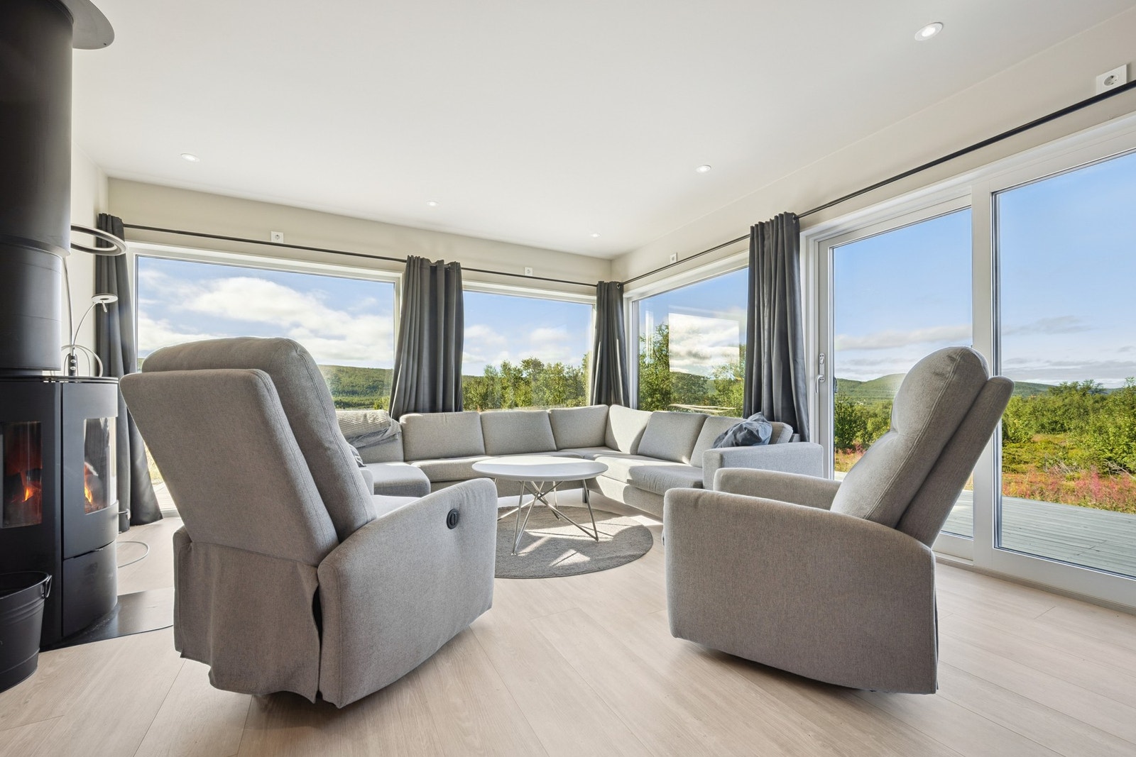 Legg merke til de store vindusflatene som bringer naturen inn i stuen Galleribilde