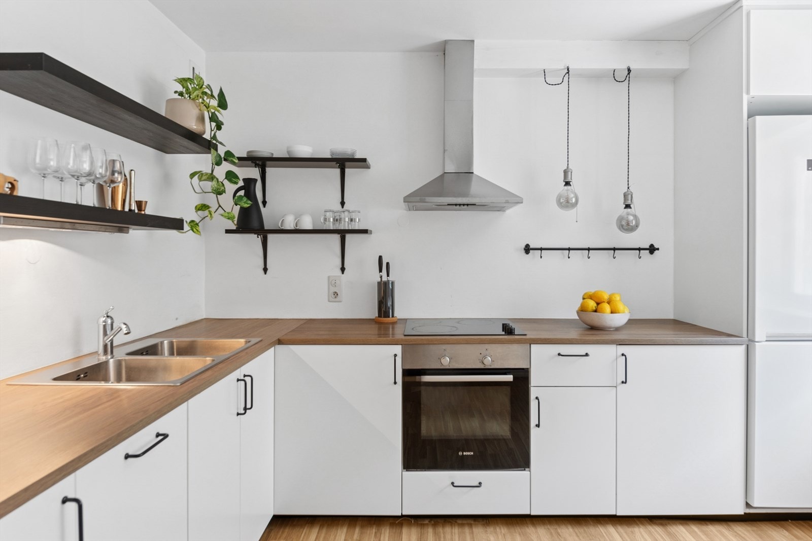 Stilrent kjøkken med veggmontert kjøkkenventilator med avtrekk ut. Galleribilde