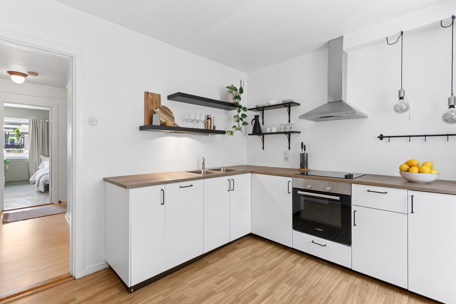 Lys kjøkkeninnredning med laminerte skrog og laminert benkeplate. Galleribilde