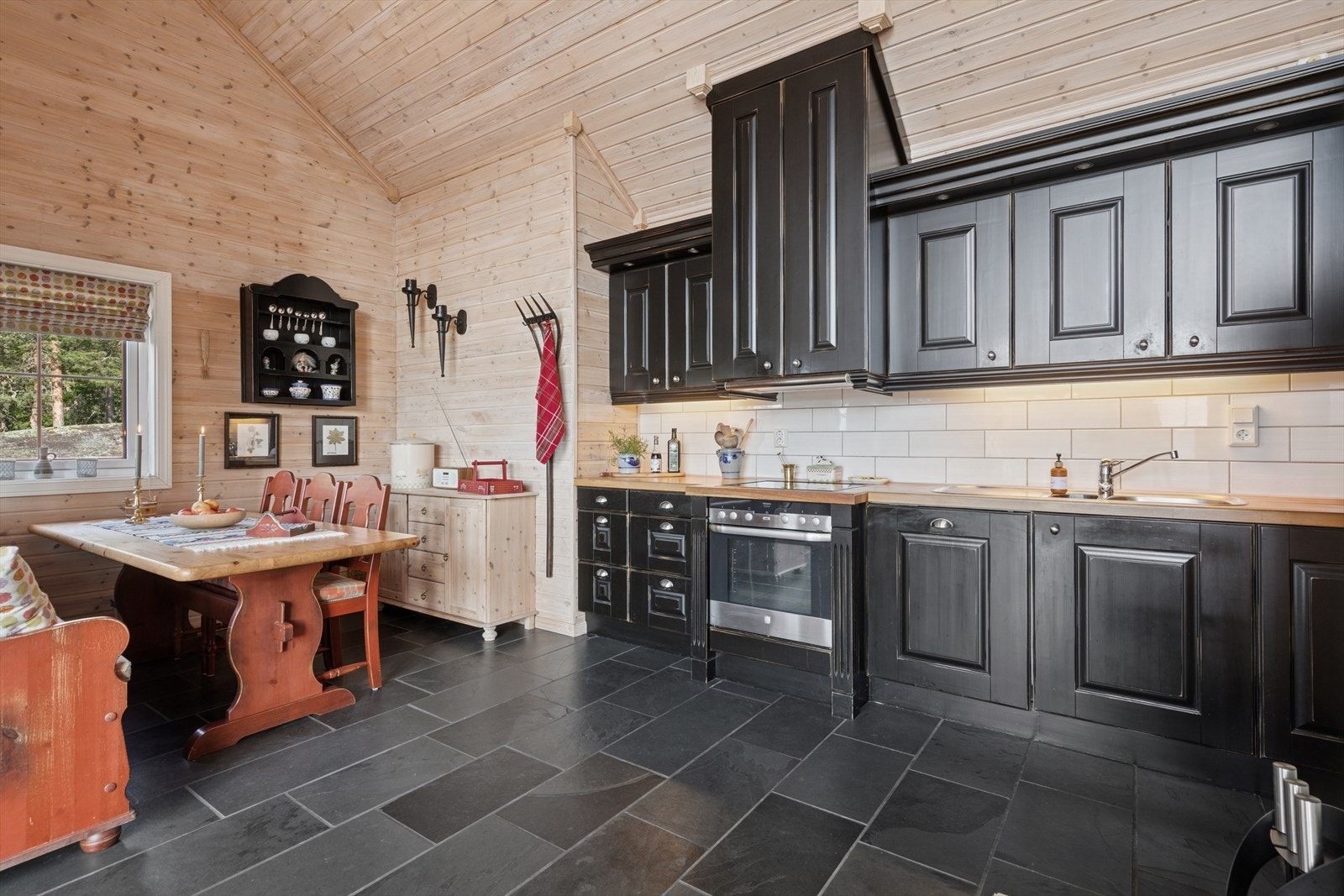 Den åpne løsningen mellom stue og kjøkken gjør rommet ekstra lyst og det er plass til mange gjester til bords. Galleribilde