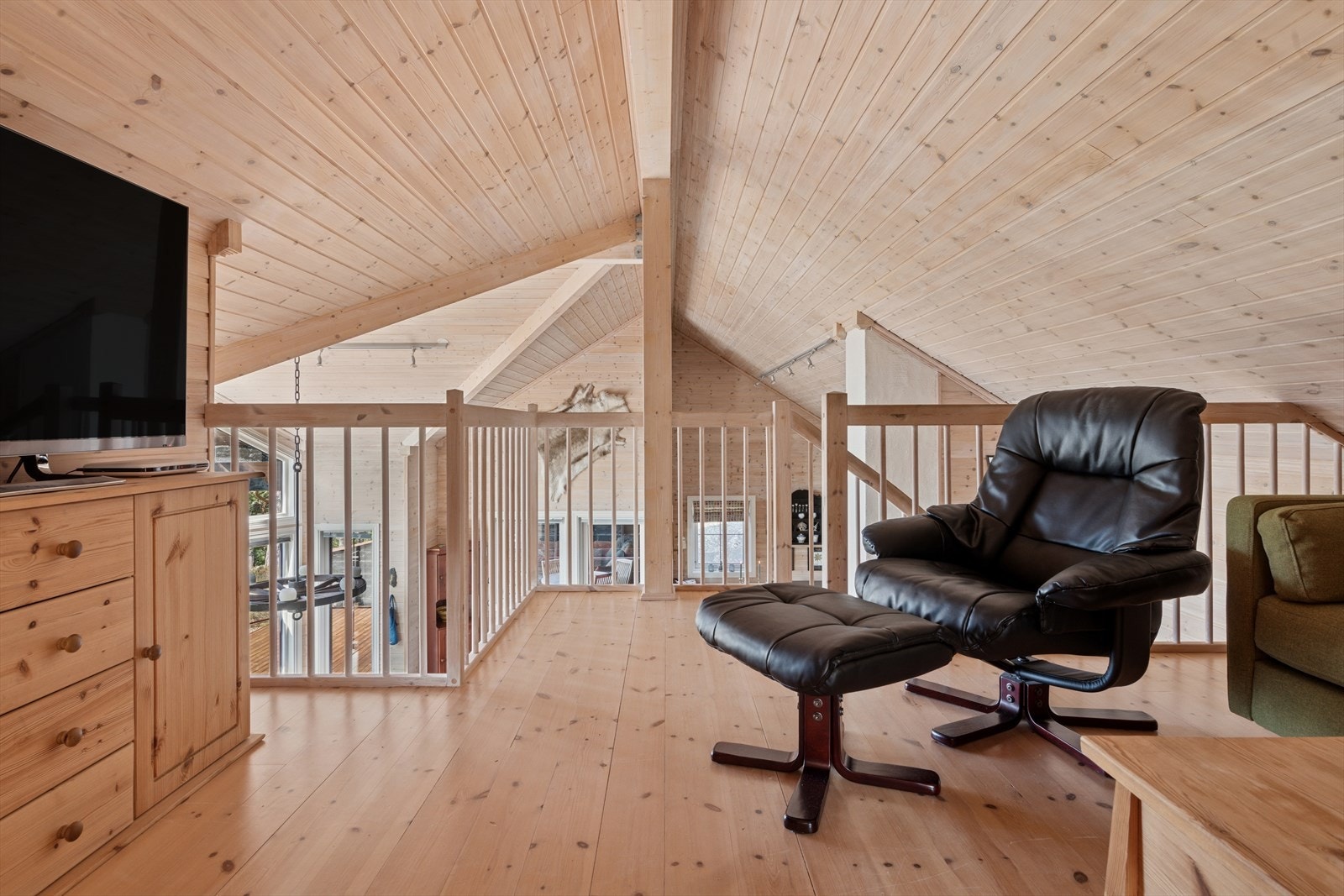 Lun loftstue hvor man slapper av foran TV i sofakroken. Galleribilde