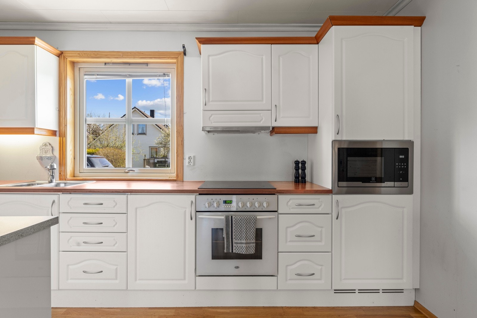 Lyst og fint kjøkken med klassiske profilerte fronter, slitesterk laminat benkeplate og integrerte hvitevarer - perfekt for både hverdagsmat og gjestemiddager. Galleribilde